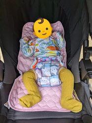 Baby sleeping in the stroller in a shirt with an extra seam