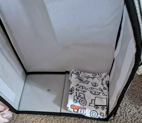 A onesie folded into triangle inside a storage box