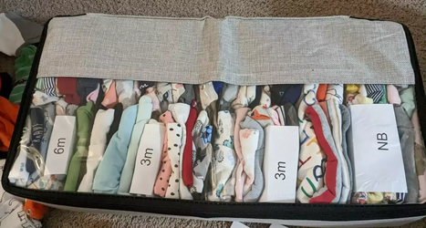 An organizer with baby clothes sorted by size